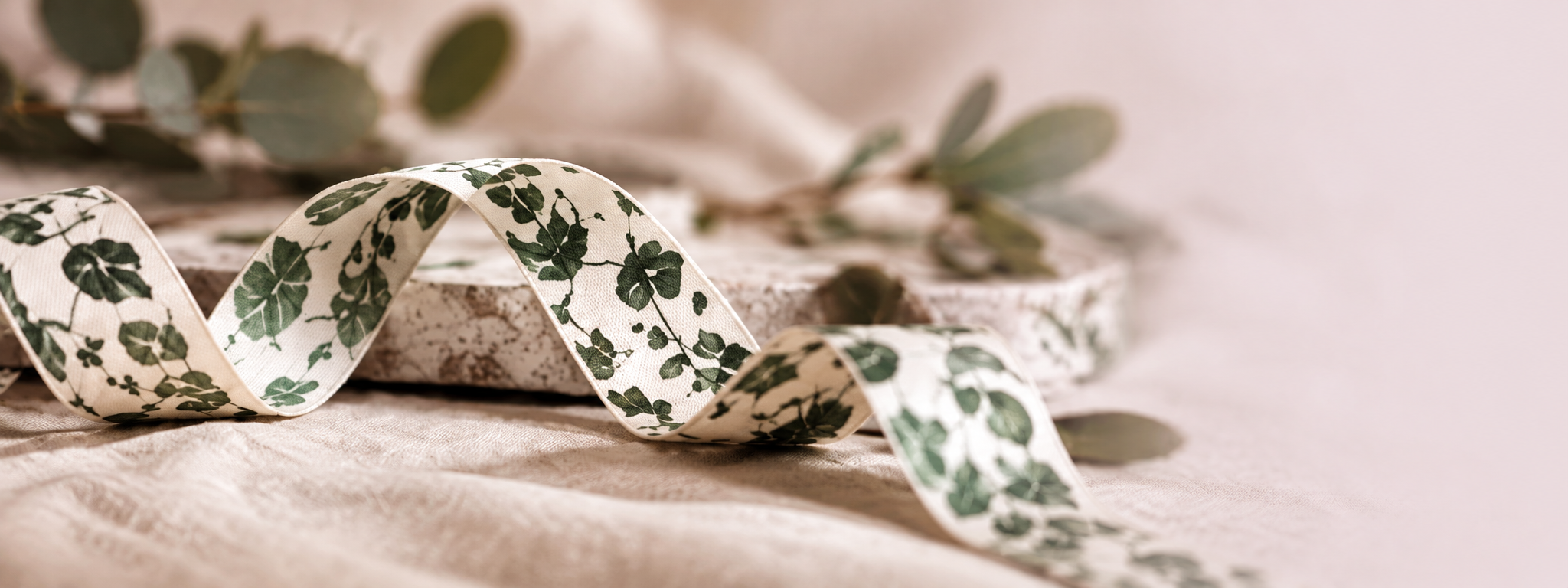 Cream botanical ribbon on soft linen fading into blush